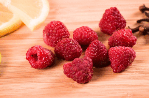 A vibrant flat lay of brain-boosting foods including berries and lemon on a rustic wooden table representing the food for brainhealth.
