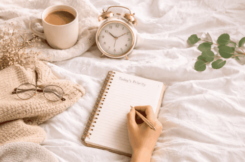 Woman writing in a notebook beside coffee and alarm clock during a calm 5 minute morning routine before work.